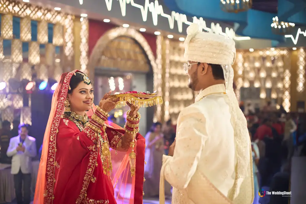 Bride welcoming the groom with an aarti thali on the stage at a Kashi Dham Lawn Varanasi wedding by The WeddingShoot